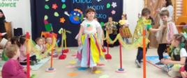 Dzieci ubrane w przygotowane przebrania z recyklingu, idą po "wybiegu" - kolorowym dywanie