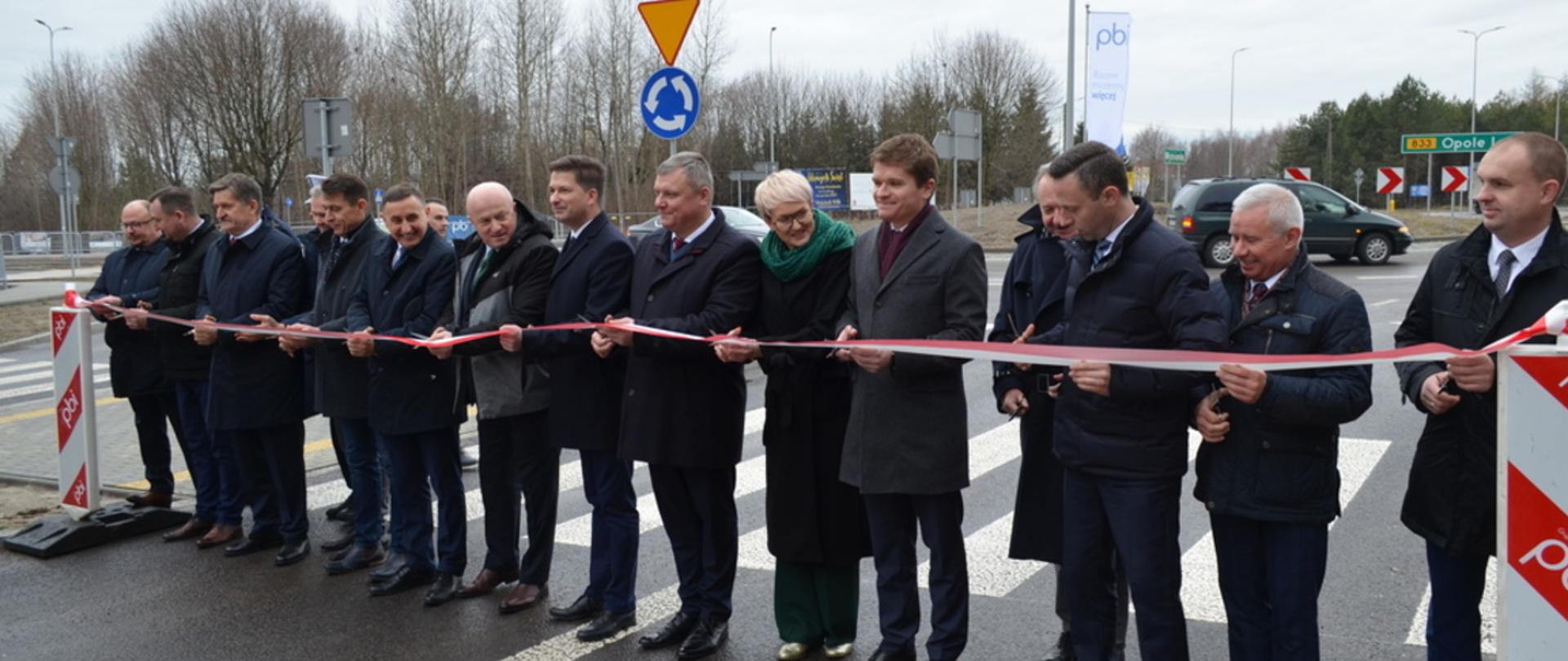 Na zdjęciu 15 osób, które oficjalnie przecinają wstęgę na drodze numer 833.