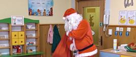 Mężczyzna przebrany za Mikołaja wchodzi do sali