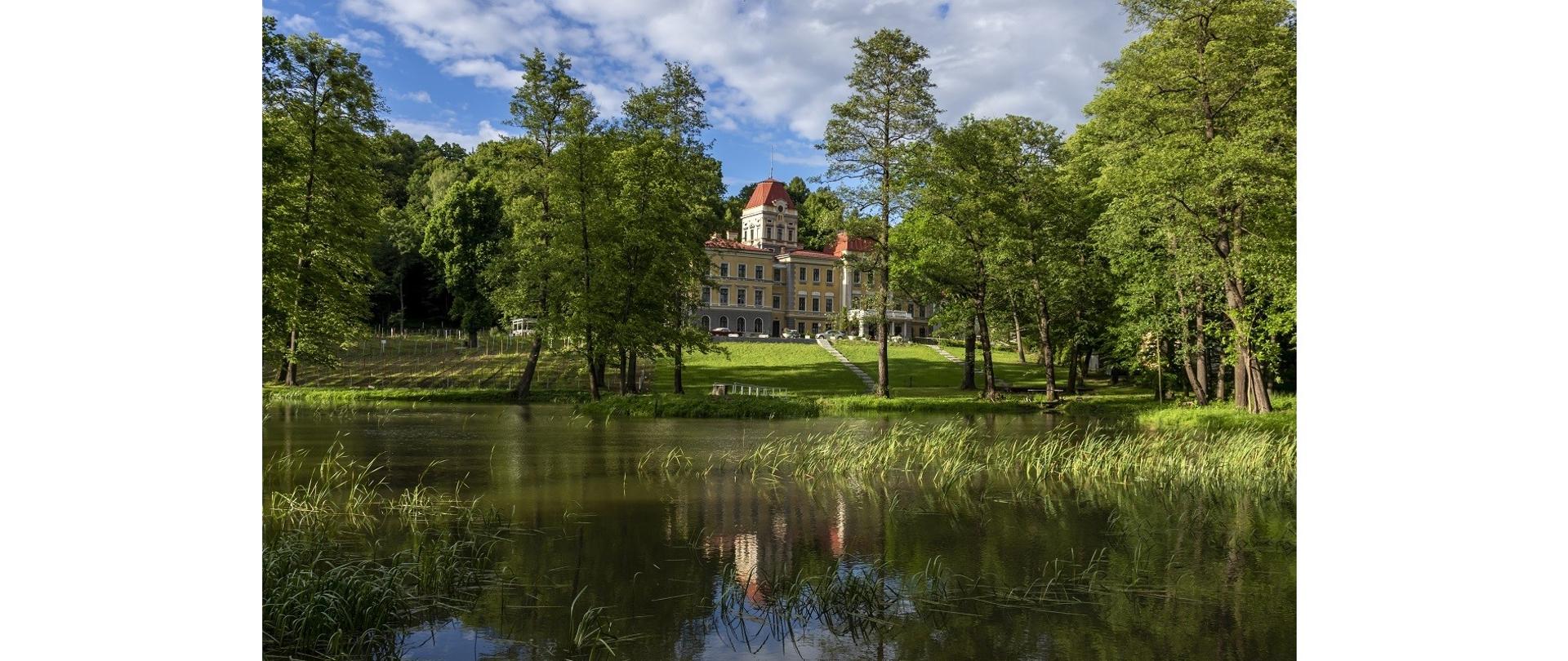 Pałac w Kończycach Wielkich. Fotografia wykonana spoza stawu, w którym budynek pałacu się odbija. Fot. Joanna Posiak (Archiwum GOK w Hażlachu)