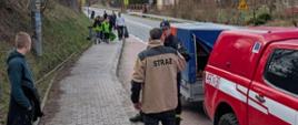 Uczestnicy sprzątania ziemi wraz ze strażakami OSP podczas akcji sprzątania.
