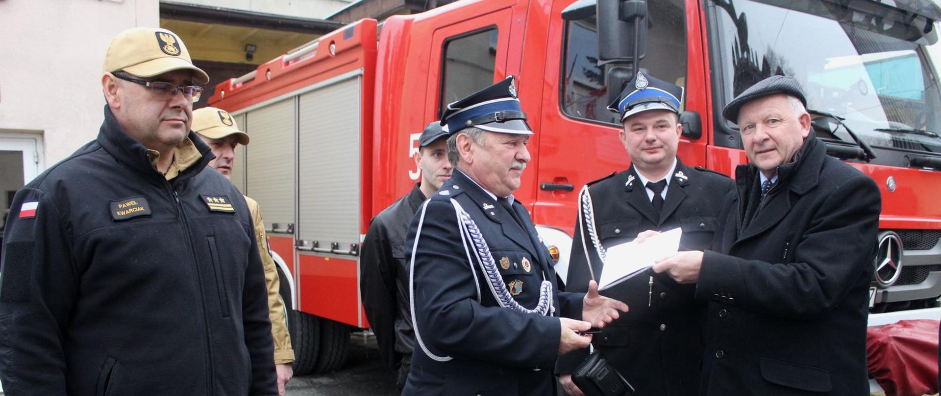 W tle samochód pożarniczy, na pierwszym planie stoją Burmistrz Miasta Augustyn Ormanty, Prezes OSP Barwałd Górny, Prezes PSP Paweł Kwarciak