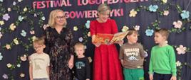 Dyrektor, dzieci i logopeda na tle dekoracji
