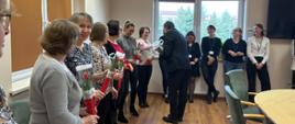 Pracownice urzędu gminy na sali obrad otrzymują tulipany od wójta Tomasza Rajcy