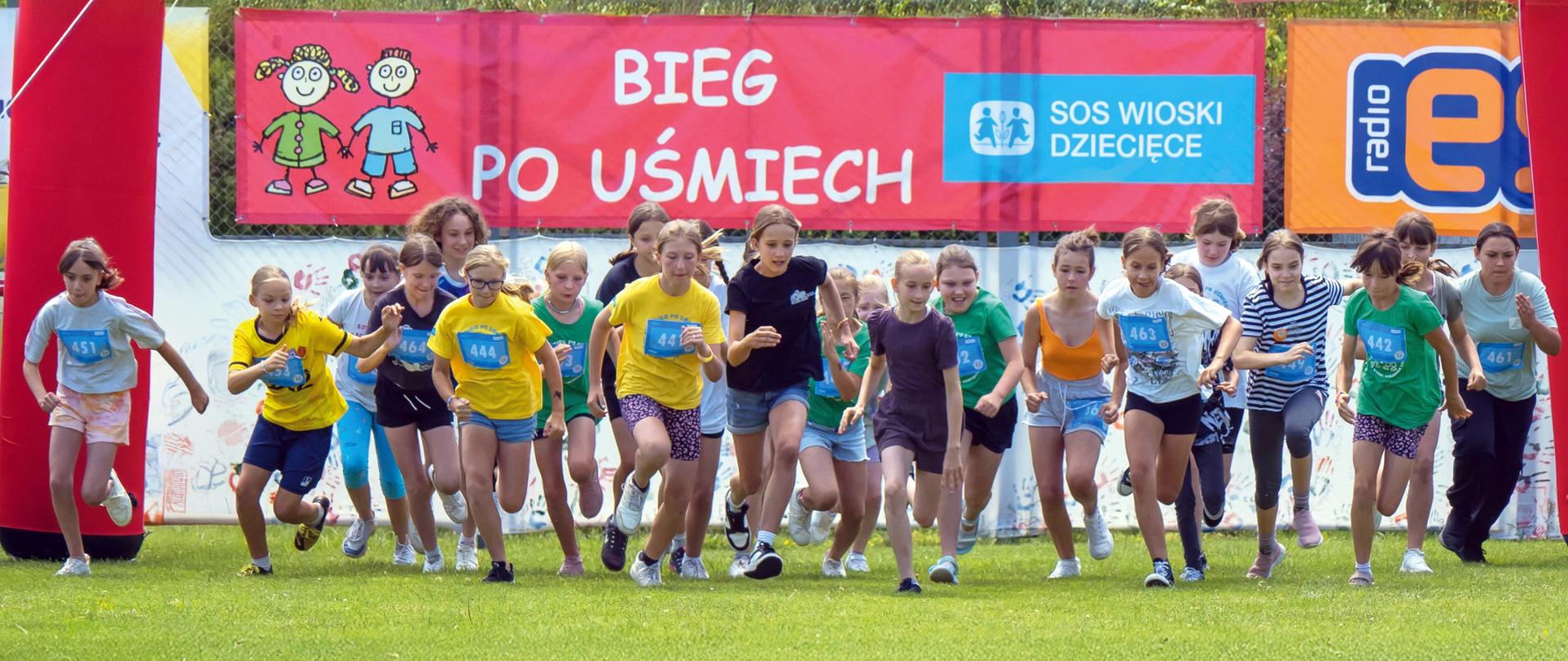 Zdjęcie przedstawia grupę biegnących dzieci podczas "Biegu po uśmiech"