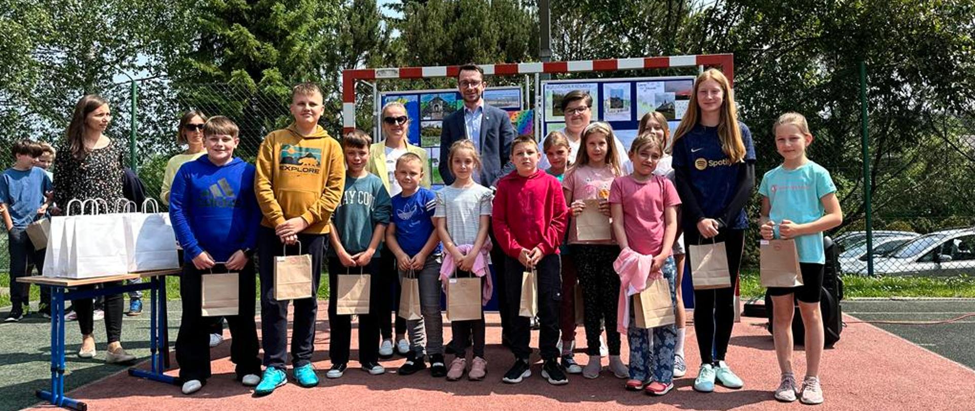 Odbiór nagród laureatów. Na zdjęciu dzieci, Pani Zastępca Dyrektora Szkoły Podstawowej w Rokicinach Podhalańskich, przedstawiciel GOPSu Paweł Wojdyła oraz Sołtys Wsi Rokiciny Nina Gryglicka.