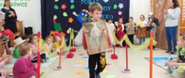 Dzieci ubrane w przygotowane przebrania z recyklingu, idą po "wybiegu" - kolorowym dywanie