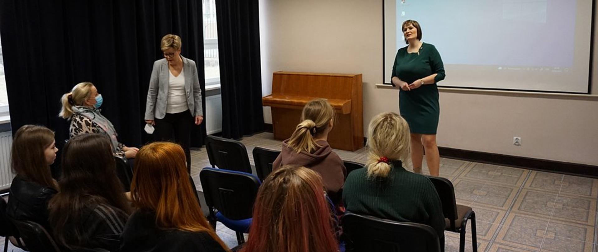 Zdjęcie przedstawia pracownika Wydziału Politologii i Dziennikarstwa UMCS w Lublinie oraz Panią Dyrektor Zespołu Szkół nr 2 w Kraśniku, które stoją na sali wykładowej. Na krzesłach siedzą uczniowie Zespołu Szkół nr 2 w Kraśniku.