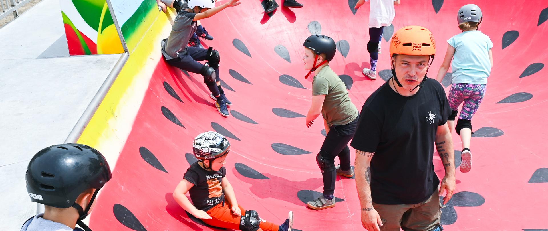 Instruktor z dziećmi w bowlu na skateparku. 