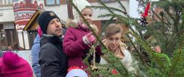 Dzieci z pomocą rodziców ubierają choinkę na Jarmarku