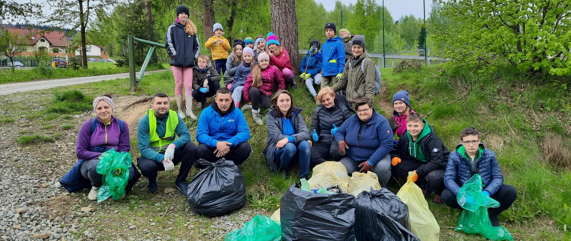 Zdjęcie przedstawia jedną z grup sprzątających świat z workami śmieci pozujących do zdjęć.