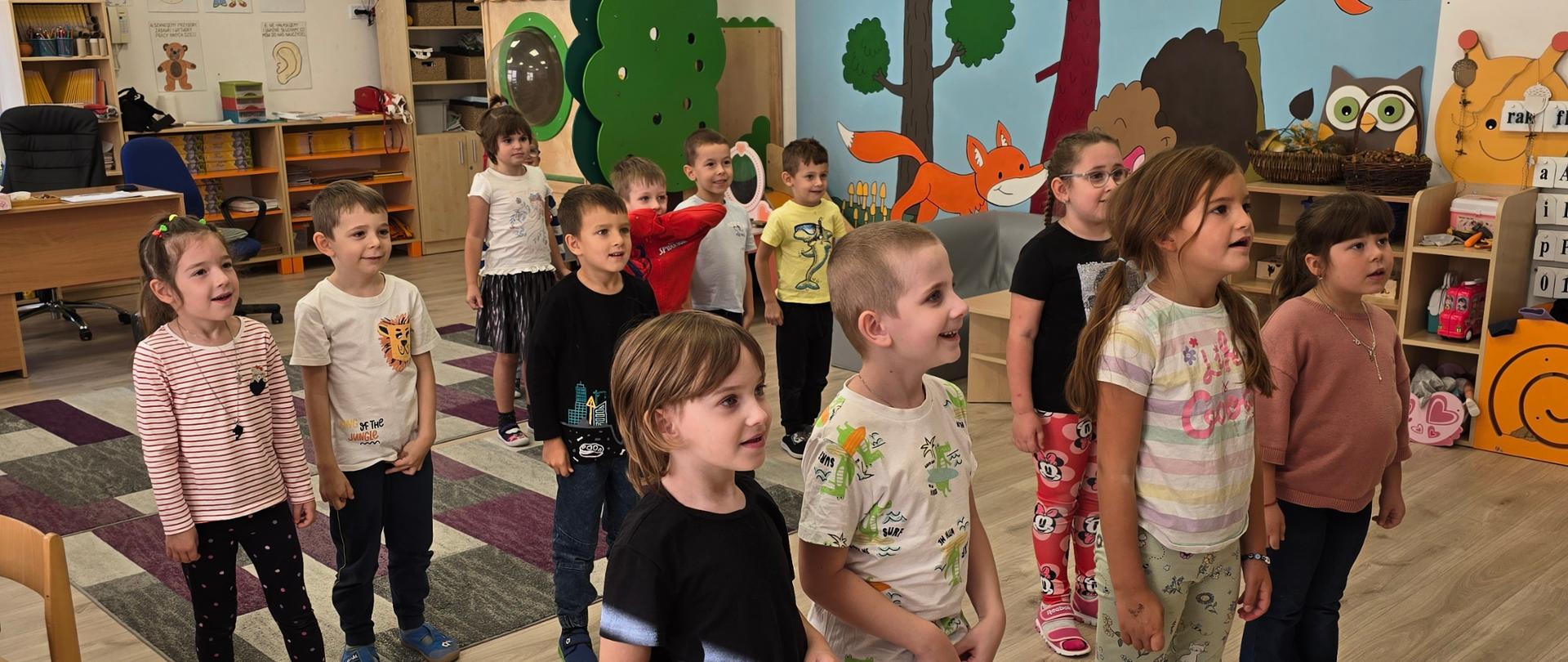 Zajęcia ruchowe - dzieci ćwiczą w sali przedszkolnej