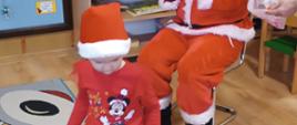 Mikołajki w przedszkolu - Mikołaj rozdaje dzieciom prezenty