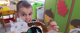 Dzieci prezentują efekty warsztatów - pomalowane kotki
