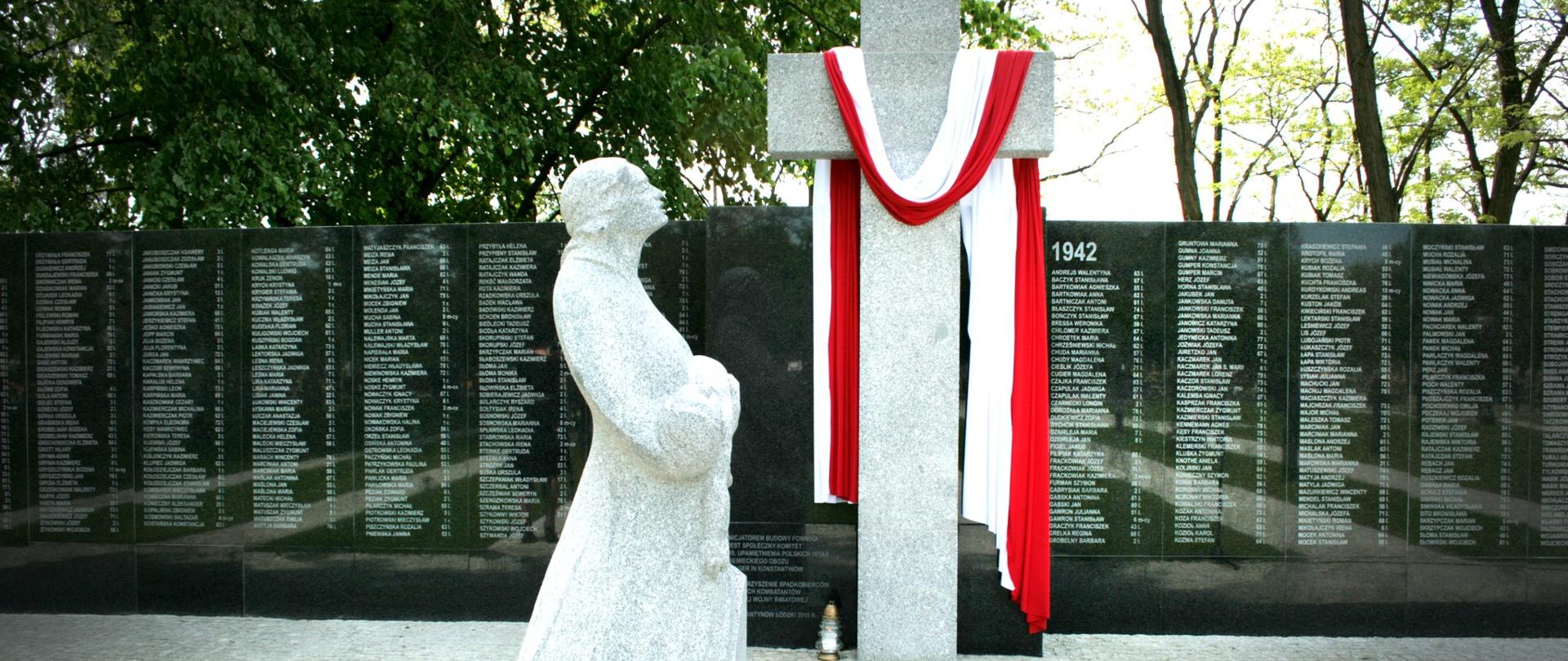Pomnik Matki Boskiej trzymającej dziecko na rękach, krzyż kamienny owinięty podłużną flagą Polski oraz tablica z nazwiskami ofiar wojny.