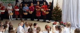 Nauczyciele występują przed dziećmi z koszami prezentów