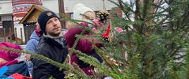 Dzieci z pomocą rodziców ubierają choinkę na Jarmarku