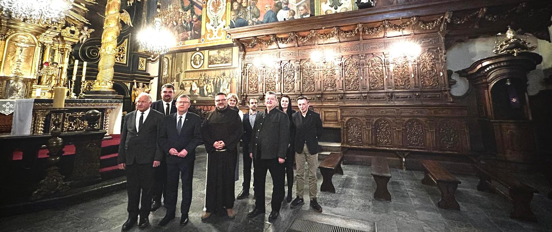 Zdjęcie z wnętrza Bazyliki Kalwaryjskiej, w tle dzieło W.Tetmajera na pierwszym planie grupa stojących osób