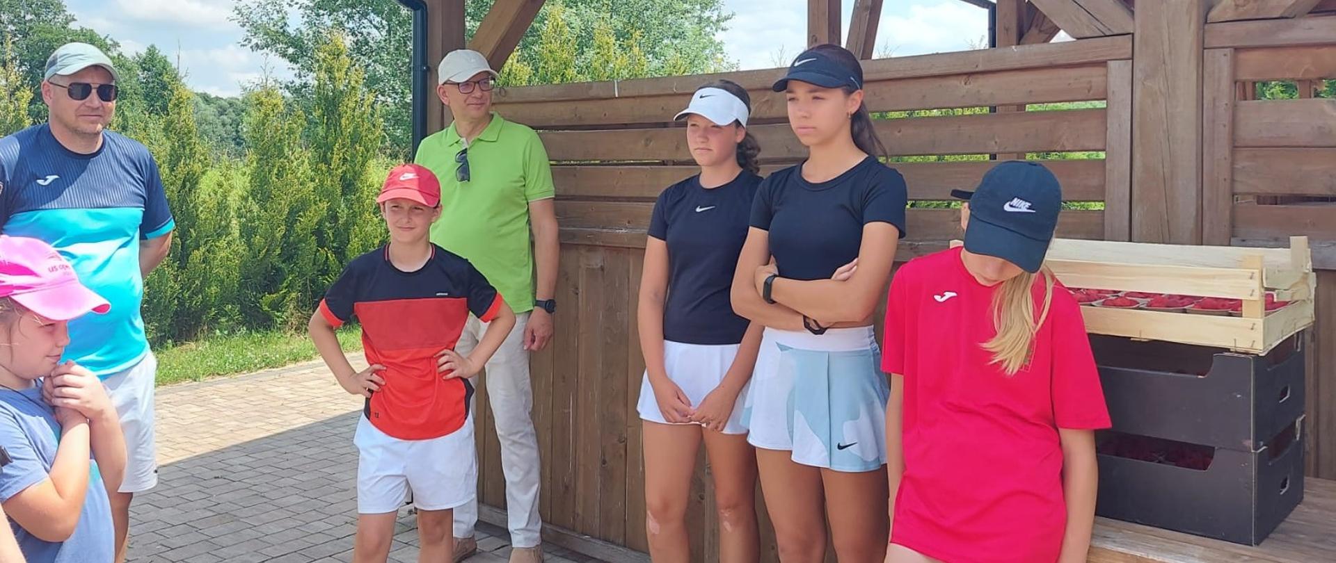 Uczestnicy turnieju w Dzierzkowicach wraz z Członkiem Zarządu Powiatu w Kraśniku Markiem Kołtunem stojący obok drewnianej altany 