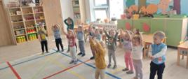 Zajęcia ruchowe - dzieci ćwiczą w sali przedszkolnej