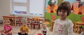 Zajęcia grupowe - dziewczynka pozuje z pluszową kostką