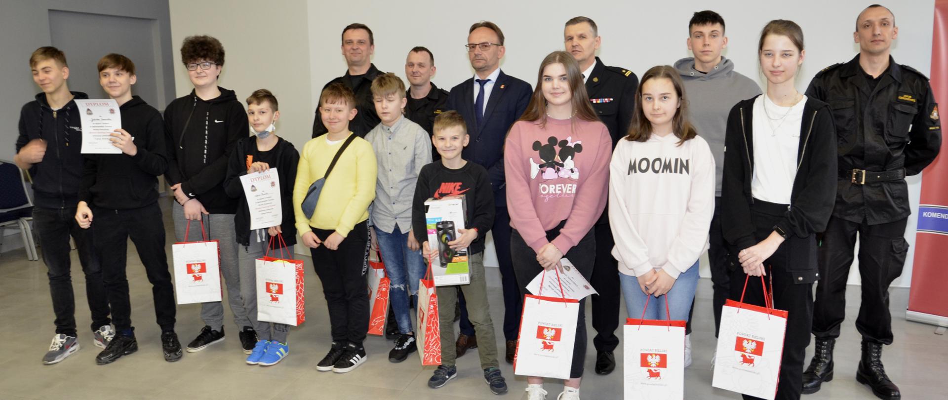 Uczestnicy Turnieju Wiedzy Pożarniczej na wspólnej fotografii z wicestarostą Piotrem Bożko, komendantami i funkcjonariuszami KP PSP w Bielsku Podlaskim