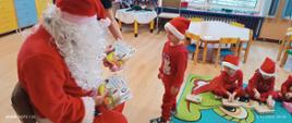 Mikołajki w przedszkolu - Mikołaj rozdaje dzieciom prezenty