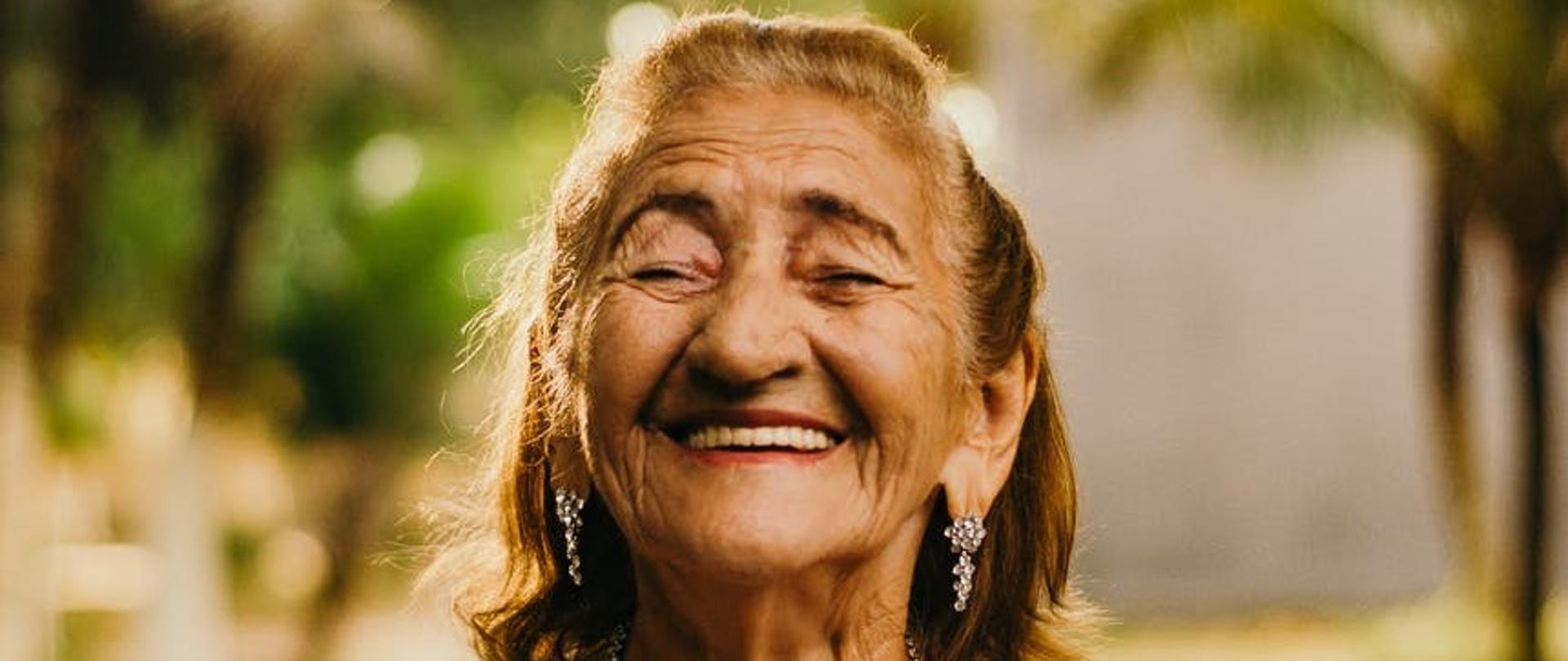 grafika przedstawia starszą uśmiechniętą osobę