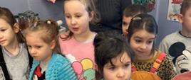 Dzieci stoją przy tablicy w klasie