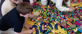 Dzieci w trakcie zabawy klockami lego - układają poszczególne elementy, pozują do zdjęć