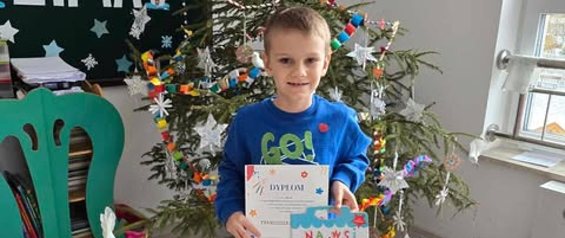 Franio pozuje z dyplomem i nagrodą