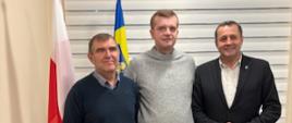 Paweł Myrda, Sołtys wsi Sieniawa Tadeusz Chlebek oraz Wójt Gminy Raba Wyżna Tomasz Rajca pozują do zdjęcia. Za nimi jest flaga Polski oraz flaga z herbem Gminy Raba Wyżna