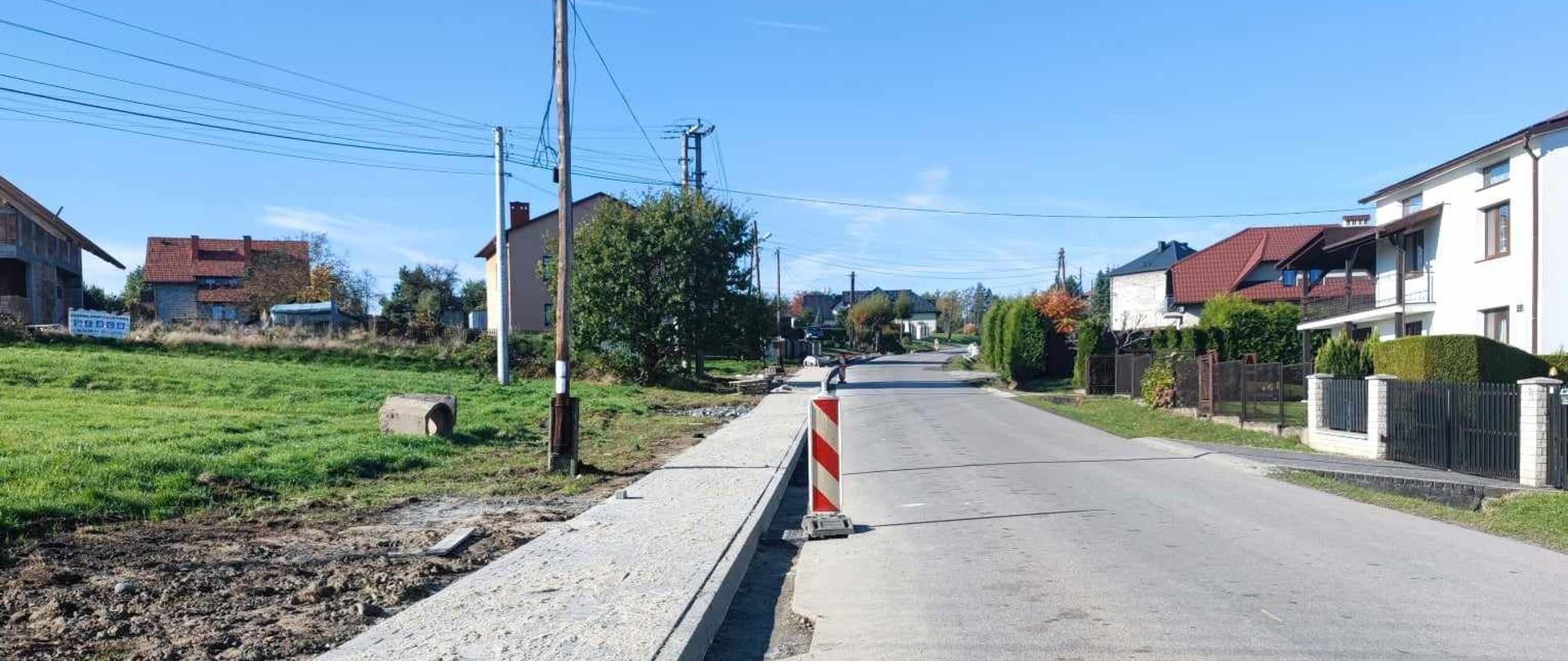 Na zdjęciu widoczny jest nowo wybudowany chodnik oraz droga.