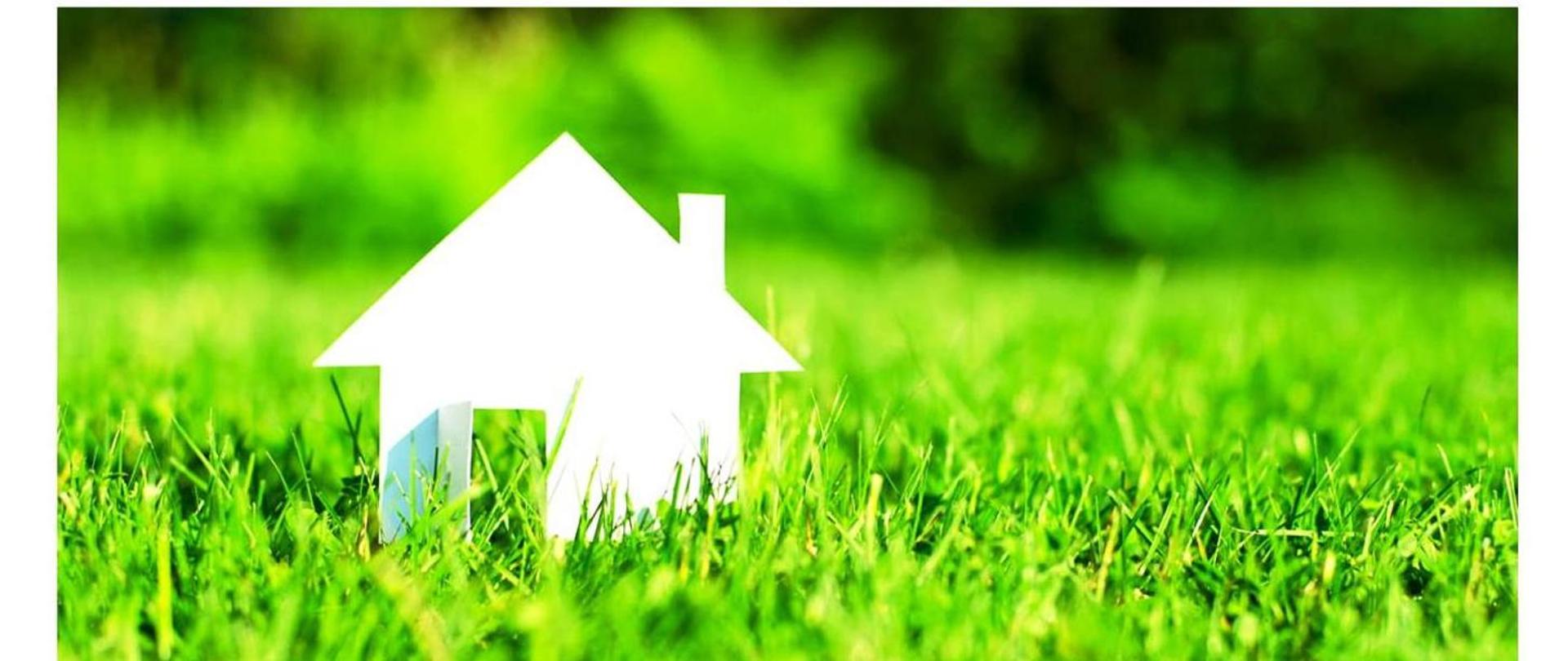 Zdjęcie przedstawia trawnik na którym widać biały miniaturowy domek 