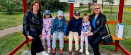 Przedszkolaki wraz z wychowawcą i Panią Dyrektor pozują do zdjęcia na przystanku