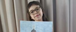 Uczestniczka konkursu pozuje do zdjęcia z dyplomem