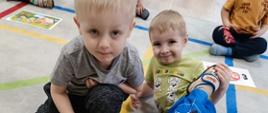 Dzieci pozują do zdjęcia przed ułożoną przez siebie układanką