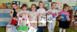 Społeczność przedszkolna pozuje z zebranymi rzeczami