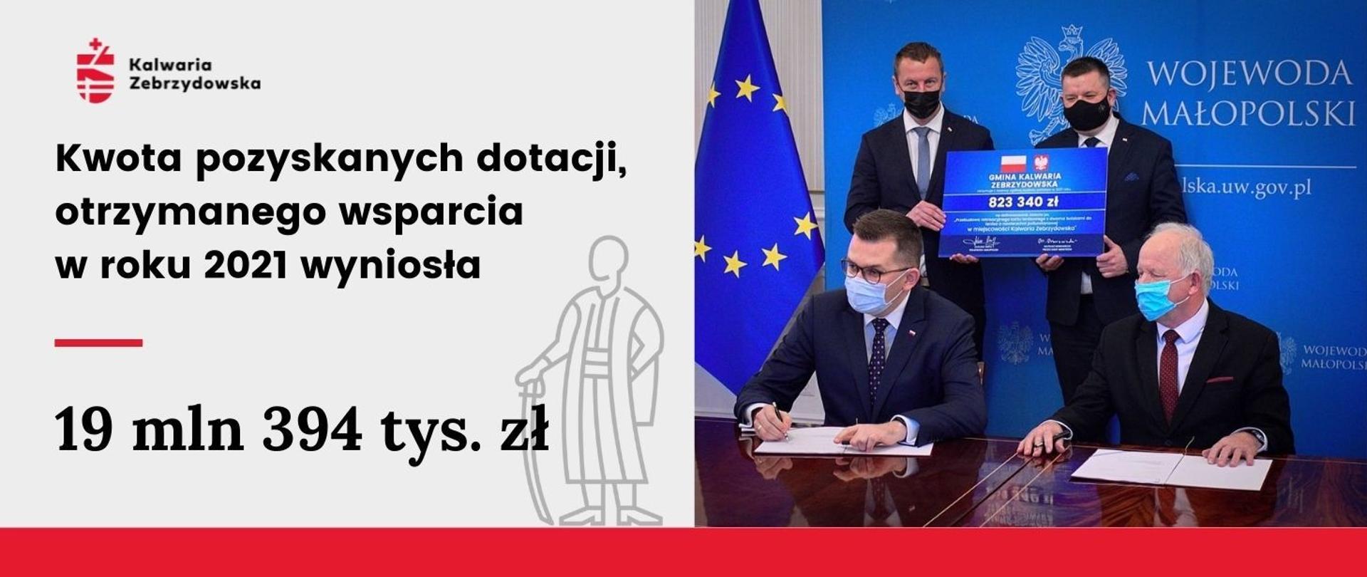 Ilustracja - Gmina Kalwaria Zebrzydowska otrzymała 19 mln 394 tys. zł wsparcia i dotacji. Na planszy widoczny na pierwszym planie Wojewoda Małopolski Łukasz Kmita, Burmistrz Miasta Augustyn Ormanty. 