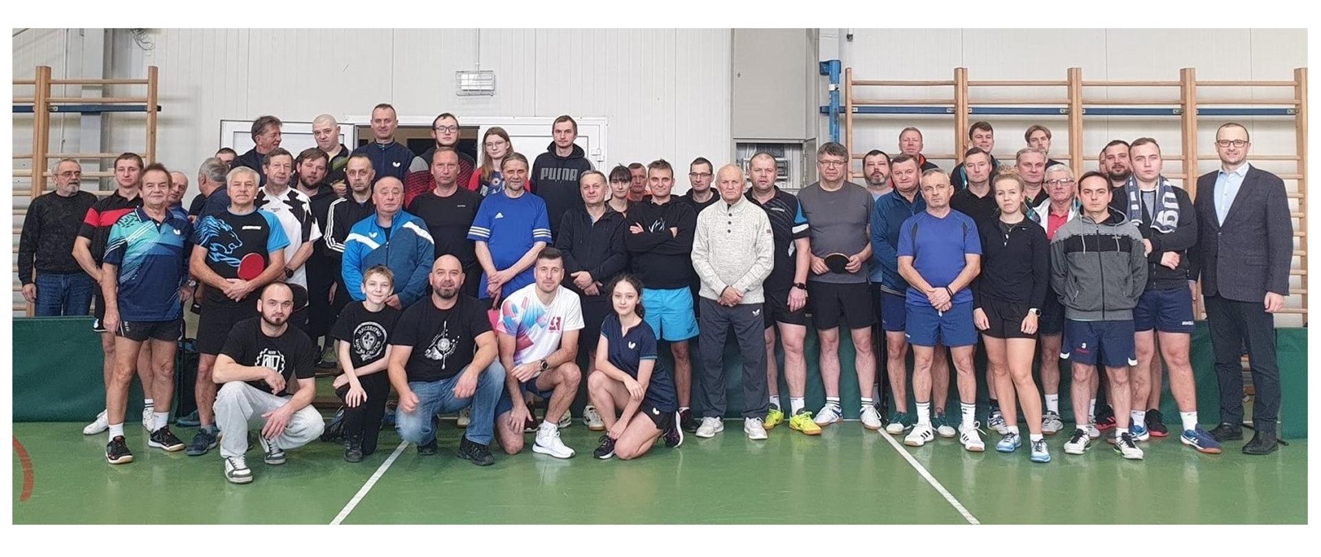 Uczestnicy XX Memoriału Jana Pomiećki. Pamiątkowa fotografia wykonana na sali gimnastycznej