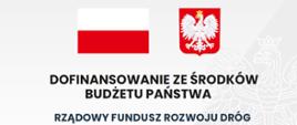 Fragment tablicy informacyjnej inwestycji zrealizowanej dzięki dofinansowaniu ze Środków Rządowego Funduszu Rozwoju Dróg - flaga i godło Polski