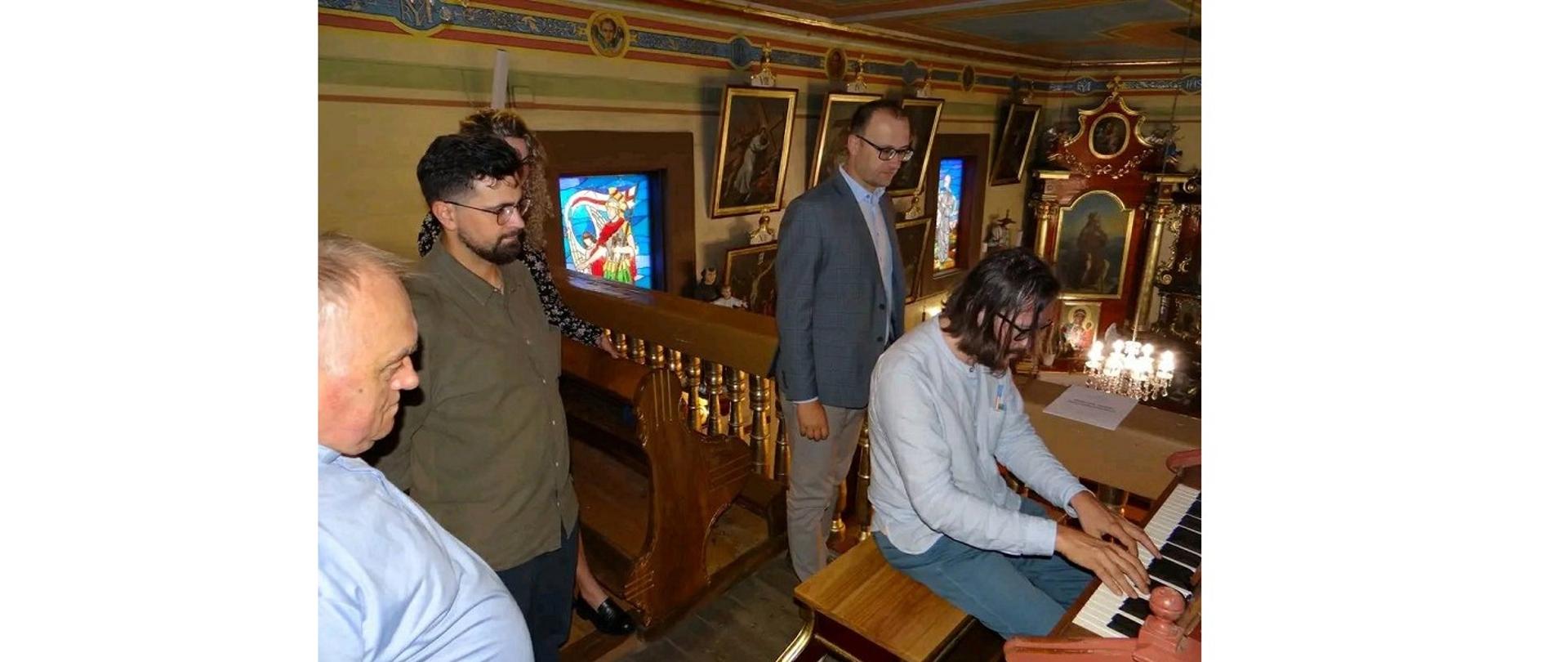 Odbiór końcowy prac remontowo-konserwatorskich organów w kościele św. Michała Archanioła w Kończycach Wielkich z udziałem prowadzącego nad nimi nadzór szczegółowy prof. dr. hab. Piotra Rojka, kierownika Katedry Organów, Klawesynu i Muzyki Dawnej Akademii Muzycznej im. Karola Lipińskiego we Wrocławiu. Jego mistrzowskiej grze przysłuchuje się ks. prob. Andrzej Wieliczka, wójt Grzegorz Sikorski oraz wykonawca prac Dawid Duda. Osoby znajdują się na pawlaczu kościoła