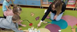Dzieci w trakcie zajęć edukacyjnych - wraz z prowadzącą zajęcia układają karty edukacyjne