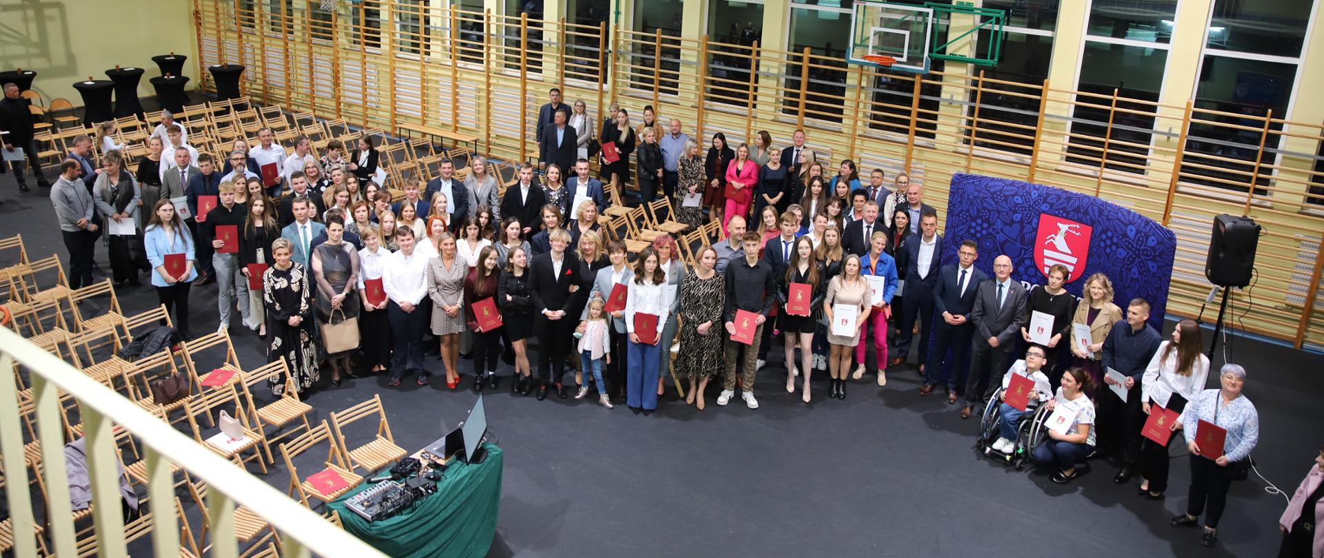 Zdjęcie przedstawia wszystkich zgromadzonych ludzi na uroczystości wręczenia Stypendiów Starosty Kraśnickiego w Zespole Szkół nr 1 w Kraśniku.