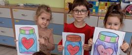 Dzieci pozują do zdjęć trzymając kolorowanki