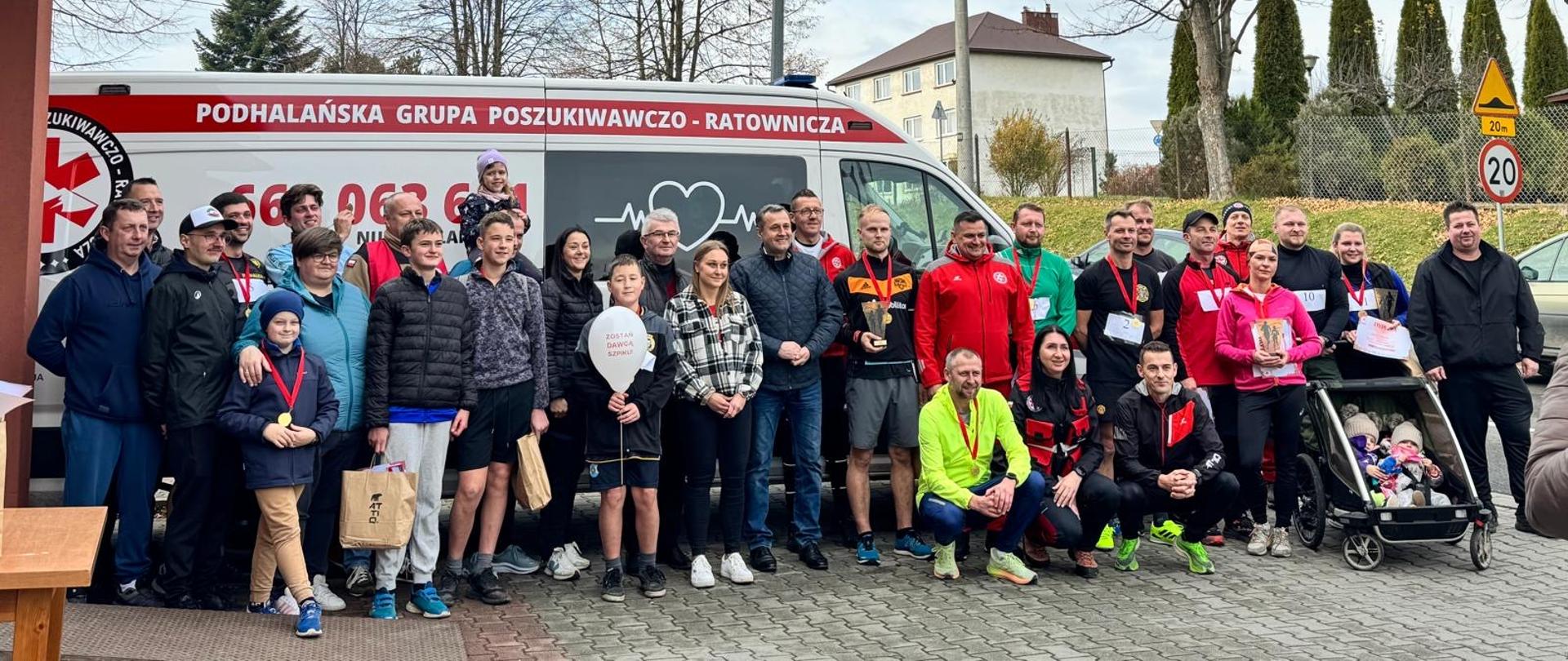 Organizatorzy wraz z uczestnikami akcji krwiodawstwa i krwiobiegu w Rabie Wyżnej na tle auta Podhalańskiej Grupy Poszukiwawczo - Ratowniczej