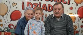 Dzieci pozują do zdjęcia z dziadkami
