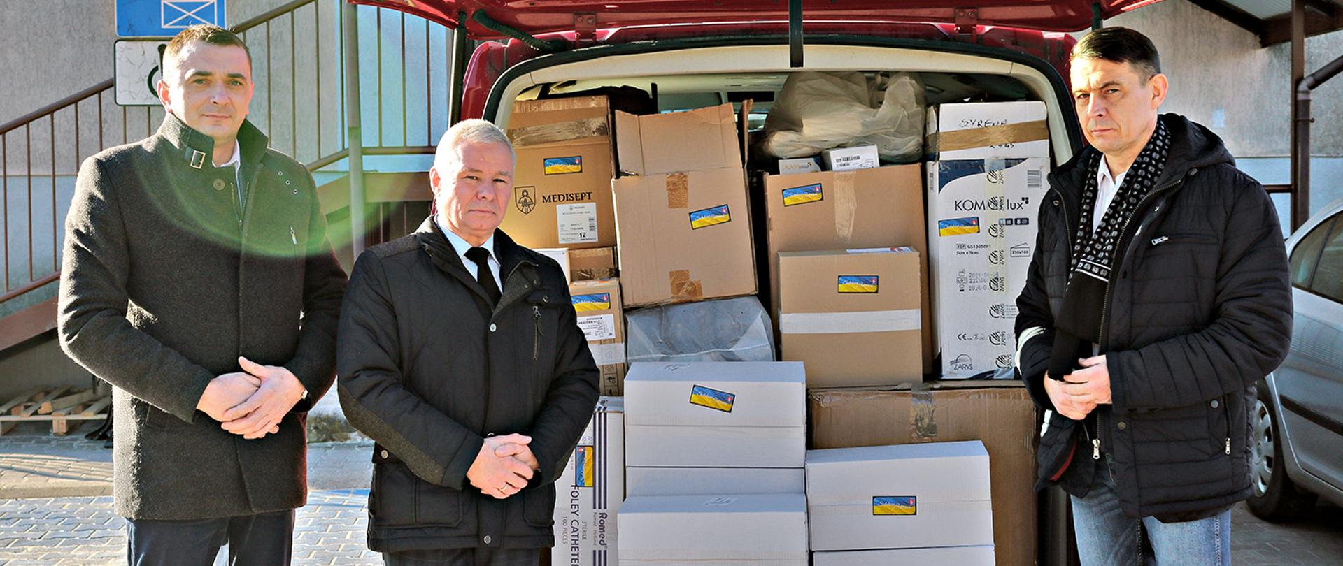 Zdjęcie przedstawia od lewej : Wicestarostę Pawła Kudrela, Starostę Andrzeja Rollę, Przewodniczącego Rady Powiatu Kraśnickiego Jacka Dubiela przy gotowym do wyjazdu transporcie pomocy medycznej dla Ukrainy.