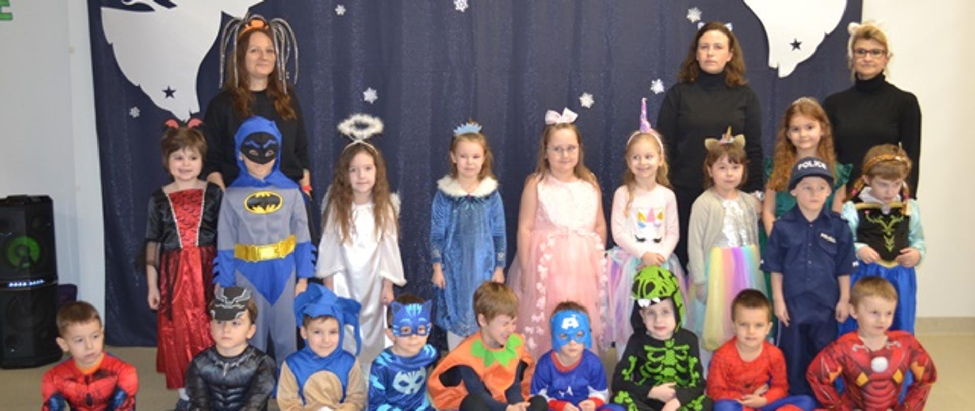 Dzieci w strojach karnawałowych pozują do zdjęcia