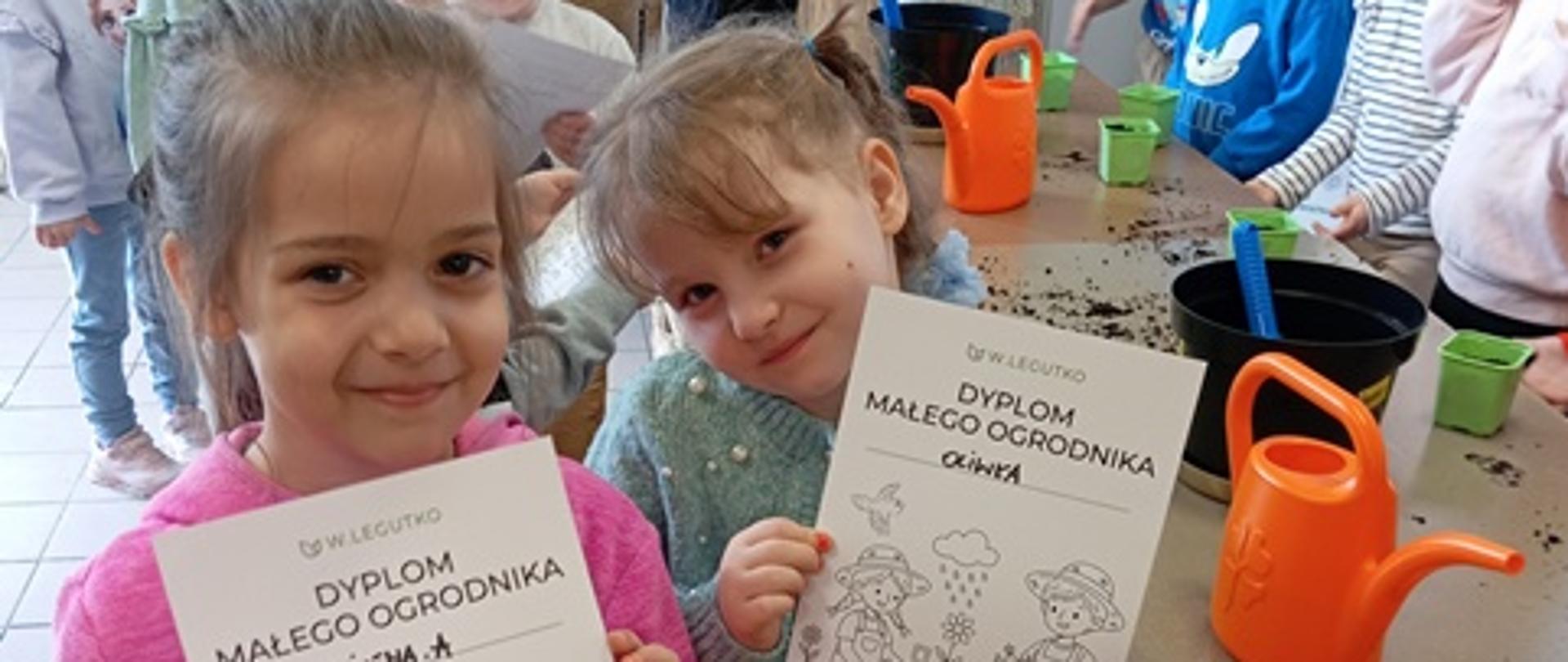 Dzieci pozują zdjęcia z symbolem małego ogrodnika